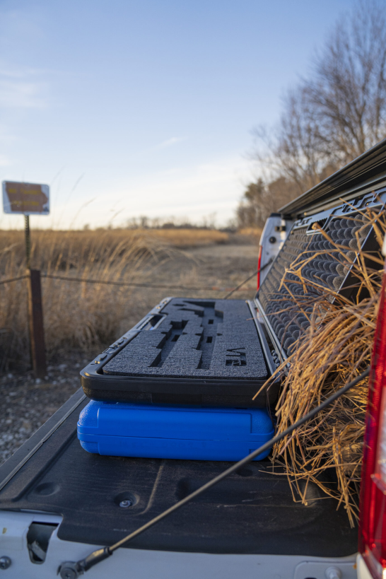 protective hard foam rifle case in truck bed on hunting property
